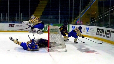 Goalie Mareks Mitens gets some air to avoid colliding with two players in Friday's hockey battle with Minnesota State.
