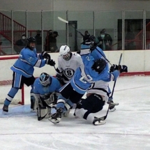 A SCRUM DEVELOPS IN FRONT OF THE PETOSKEY GOALIE AFTER HE STOPS A SHOT FRIDAY NIGHT ACITON.
