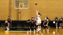 Ally Schultz fires in the three in fourth quarter action. Rudyard upset the Saints Friday night with a score of 51-47.