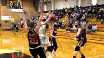 Hallie Marshall drives and charges into Desta MacDowell. Rudyard upset the Saints Friday night with a score of 51-47.