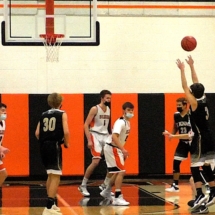 Kevin Frazier fires in a three in Rudyard boys basketball action vs St. Igance Saints Monday evening.